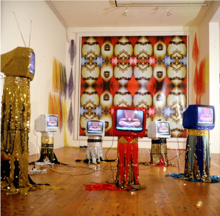 A group of decorated televisions on stands in a room.