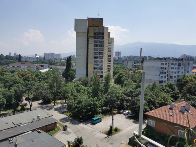 View of apartment building and other residences surrounded by streets and trees