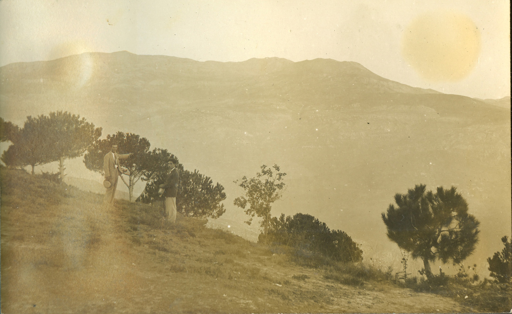 A landscape photo taken in Lebanon. Two unidentified men stand in the foreground.
